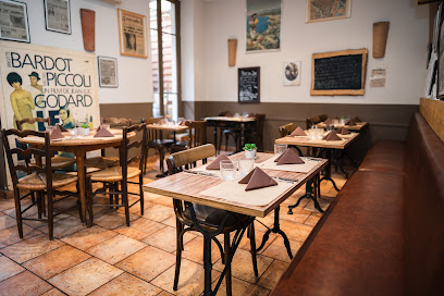 Une salle à manger vide avec ses tables dressées et ses murs décorés