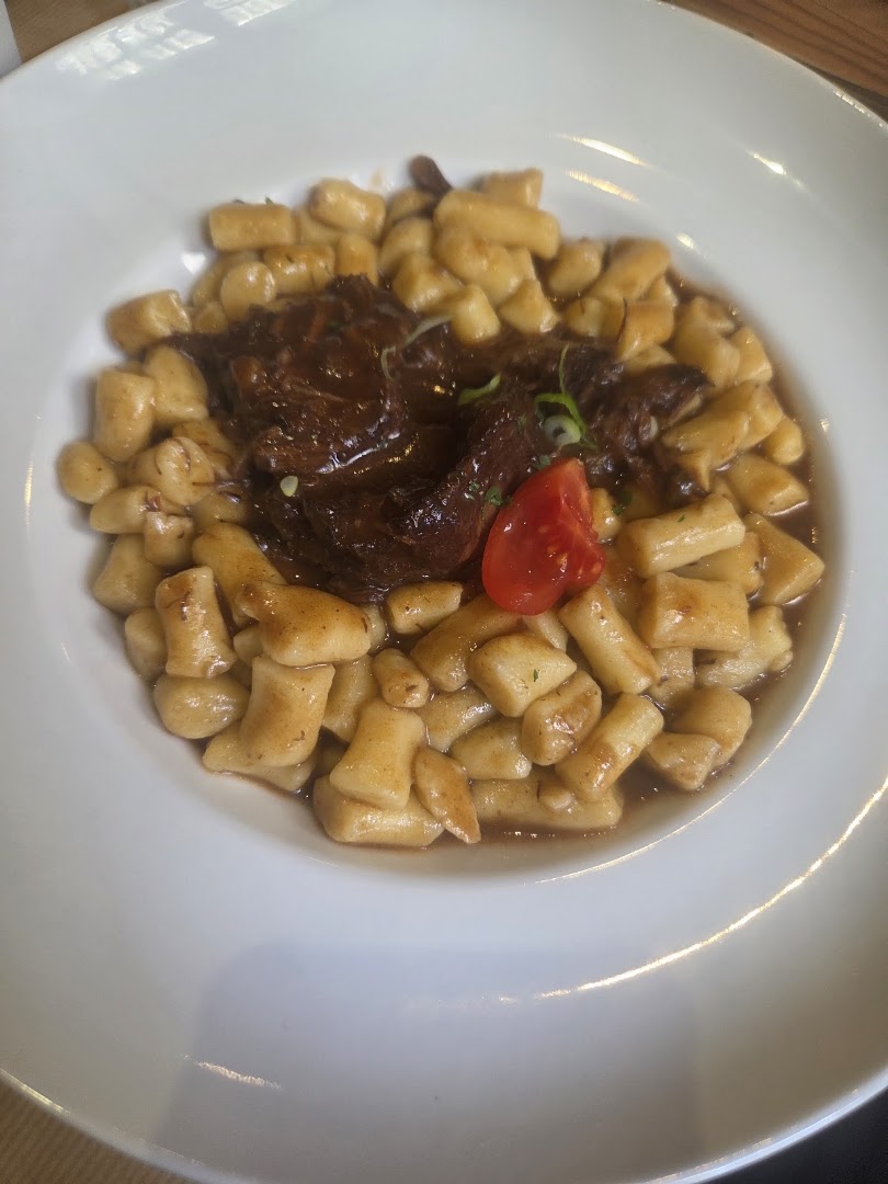 Des pâtes en quenelles servies avec une sauce brune